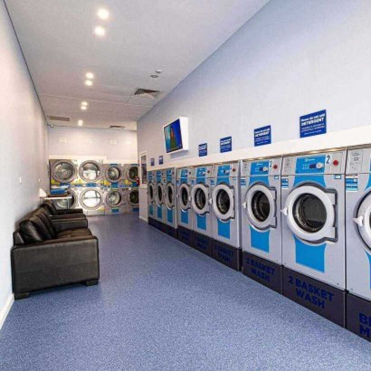 Interior of laundromat wth machines and couch